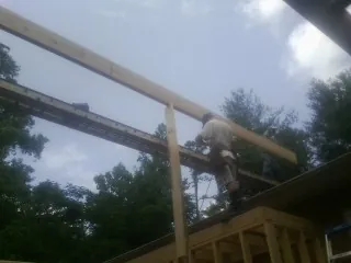 Carpenter setting a ridge beam over a new addition frame — Ice Dam Removal by Roofing Brothers in Running Springs